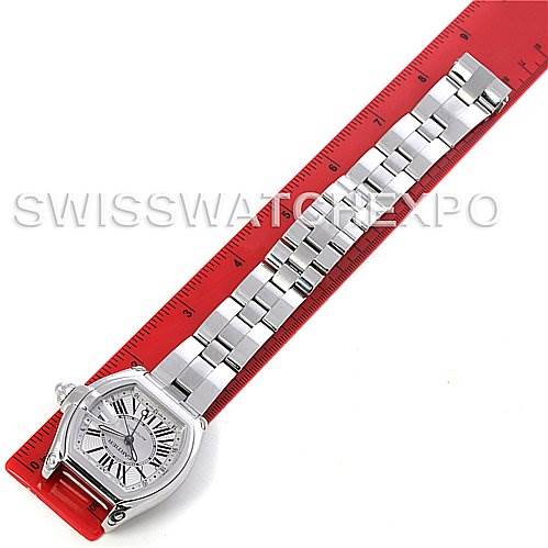 This image shows the Cartier Roadster W62032X6 Men's Stainless Steel Silver Dial W62032X6 Men's Stainless Steel Silver Dial watch laid flat with its dial and bracelet fully visible against a red ruler.