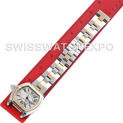 The image shows a Cartier Roadster W62031Y4 Men's Steel and Gold (two tone) Silver Dial W62031Y4 Men's Steel and Gold (two tone) Silver Dial watch placed alongside a ruler, highlighting its bracelet and watch face.