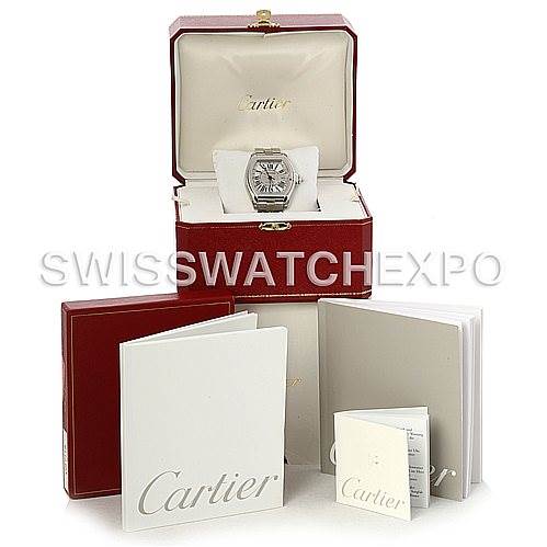 The image shows a Cartier Roadster W62032X6 Men's Stainless Steel Silver Dial W62032X6 Men's Stainless Steel Silver Dial watch in its open box, accompanied by booklets and manuals, all placed in front of the box.