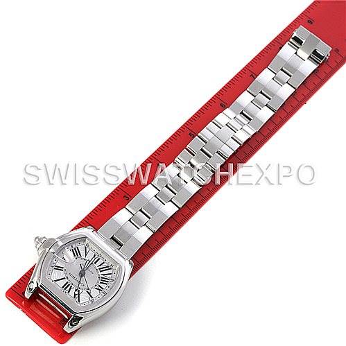 The image shows a Cartier Roadster W62032X6 Men's Stainless Steel Silver Dial W62032X6 Men's Stainless Steel Silver Dial watch placed on a red ruler, displaying the face and bracelet from a top-down angle.
