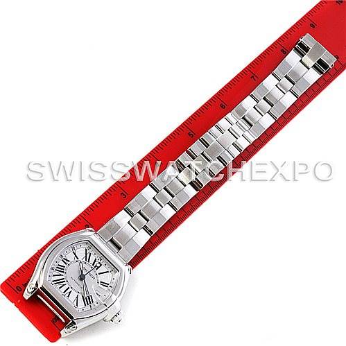 The image shows a Cartier Roadster W62032X6 Men's Stainless Steel Silver Dial W62032X6 Men's Stainless Steel Silver Dial watch laid flat next to a red ruler, displaying the watch face and the entire metal bracelet.