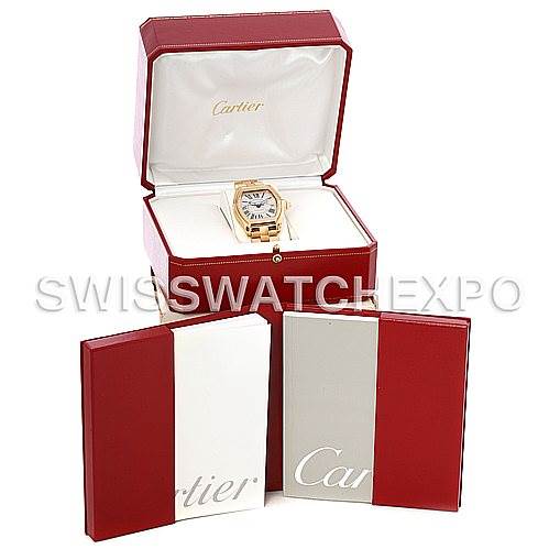 The image shows a Cartier Roadster W62005V1 Men
s Yellow Gold Silver Dial W62005V1 Men
s Yellow Gold Silver Dial watch in its open box with additional packaging and booklets displayed in front.