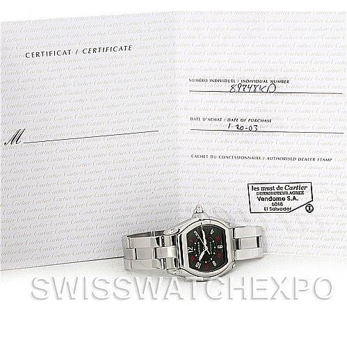 The image shows the Cartier Roadster W62002V3 Men's Stainless Steel Black Dial W62002V3 Men's Stainless Steel Black Dial watch placed in front of its certificate of authenticity and documentation.