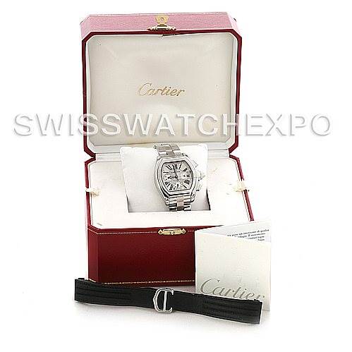 The image shows a Cartier Roadster W62019X6 Men's Stainless Steel Silver Dial W62019X6 Men's Stainless Steel Silver Dial model watch displayed in its open box, with accompanying booklet and an interchangeable black strap.