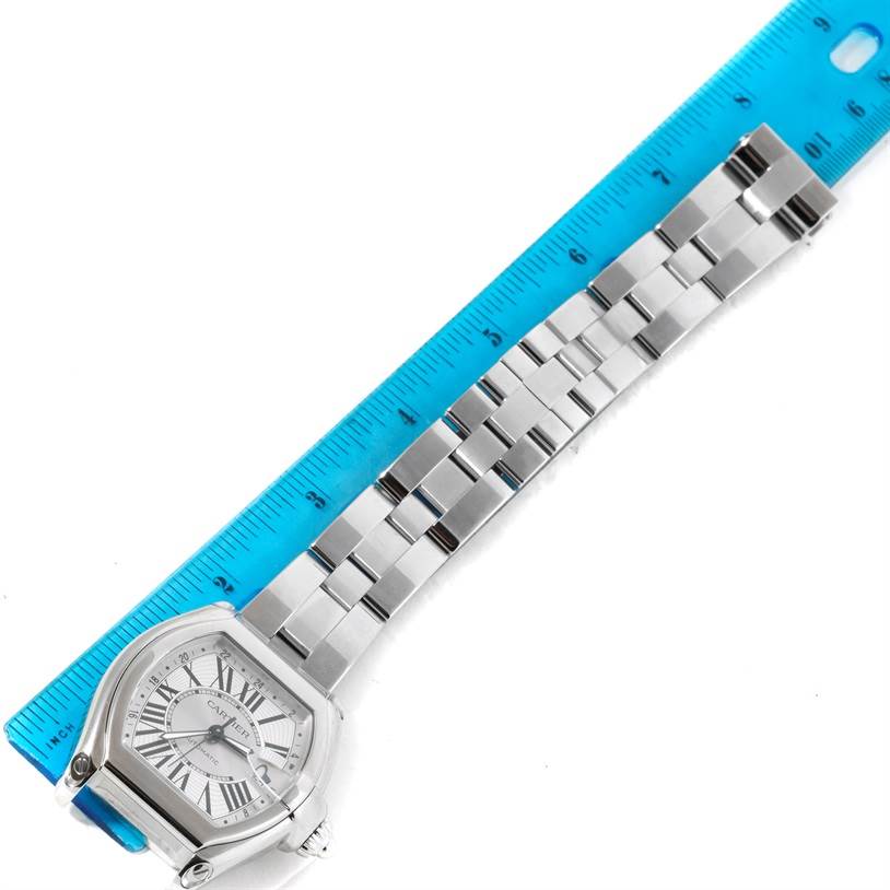 The image shows a top view of a Cartier Roadster W62032X6 Men's Stainless Steel Silver Dial W62032X6 Men's Stainless Steel Silver Dial watch, displaying the face and stainless steel bracelet along with a ruler for scale.