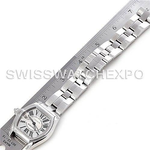 The image shows the Cartier Roadster W62025V3 Men's Stainless Steel Silver Dial W62025V3 Men's Stainless Steel Silver Dial watch laid flat next to a ruler, highlighting its face and stainless steel bracelet.