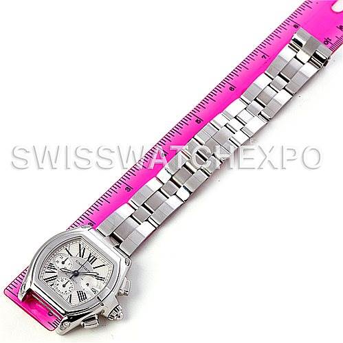 The image shows a Cartier Roadster W62019X6 Men's Stainless Steel Silver Dial W62019X6 Men's Stainless Steel Silver Dial watch laid flat on a pink ruler, prominently displaying its face and band.