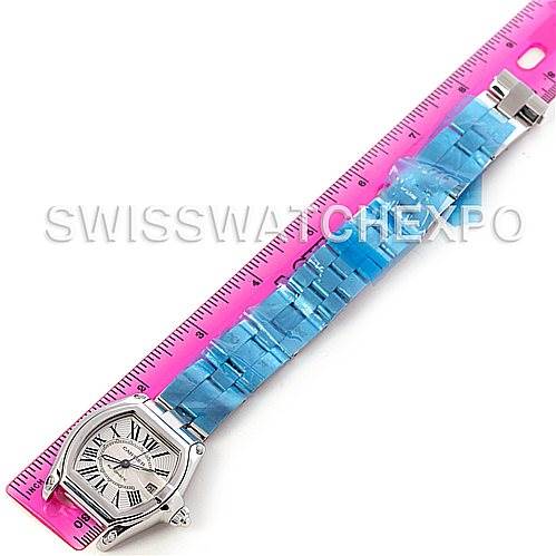 The image shows a top-down view of a Cartier Roadster W62025V3 Men's Stainless Steel Silver Dial W62025V3 Men's Stainless Steel Silver Dial watch with its bracelet laid next to a pink ruler.