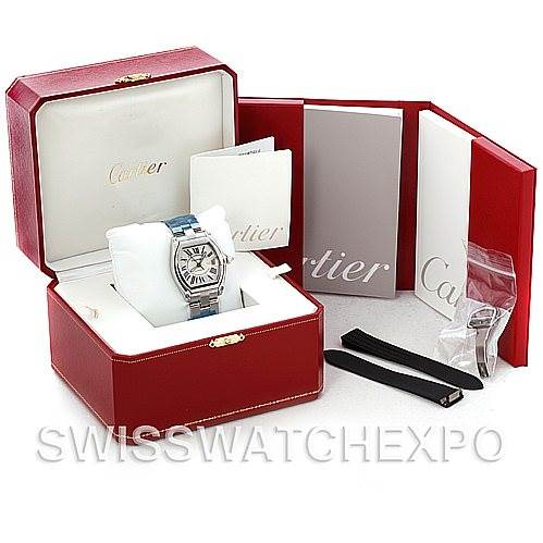 The image shows a Cartier Roadster W62025V3 Men's Stainless Steel Silver Dial W62025V3 Men's Stainless Steel Silver Dial watch with its box, manuals, and additional strap accessories.
