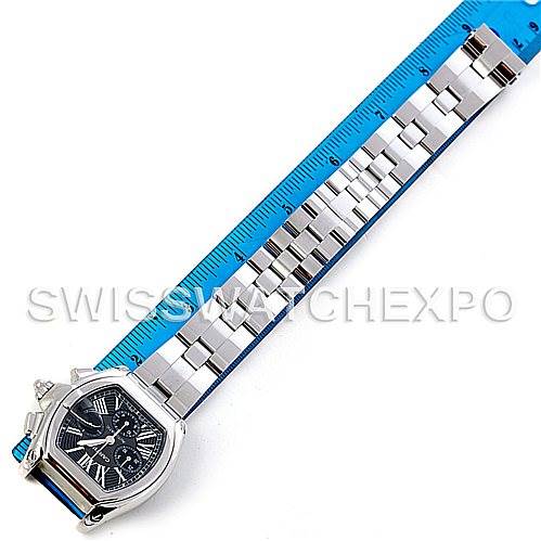 The image shows a Cartier Roadster W62020X6 Men's Stainless Steel Black Dial W62020X6 Men's Stainless Steel Black Dial watch viewed from the top, including the face and the metal bracelet along with a blue measuring scale.