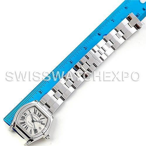 This image shows a Cartier Roadster W62025V3 Men
s Stainless Steel Silver Dial W62025V3 Men
s Stainless Steel Silver Dial watch from above, including its face and full metal bracelet next to a blue ruler.