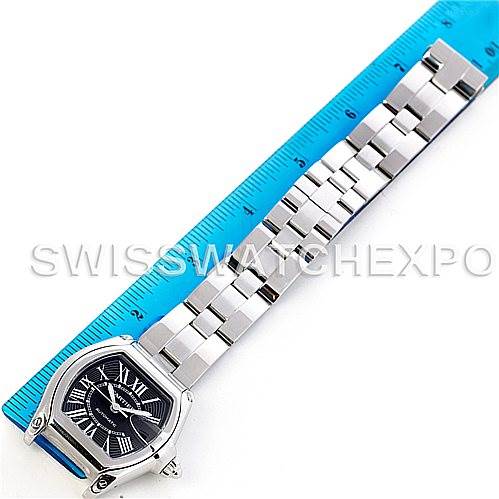 This image of a Cartier Roadster W62041V3 Men's Stainless Steel Black Dial W62041V3 Men's Stainless Steel Black Dial watch shows an overhead view of the face and entire metal bracelet, with a blue measuring ruler on the side.