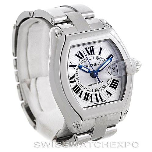 The image shows a silver Cartier Roadster W62025V3 Men's Stainless Steel Silver Dial W62025V3 Men's Stainless Steel Silver Dial watch at an angle, highlighting its face, Roman numeral dial, date display, and metal bracelet.