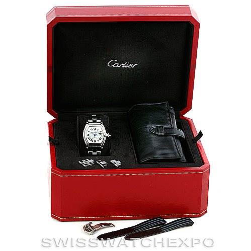 The image shows a Cartier Roadster W62025V3 Men's Stainless Steel Silver Dial W62025V3 Men's Stainless Steel Silver Dial watch and accessories, including extra links, bands, and a black case from a front angle in its red box.