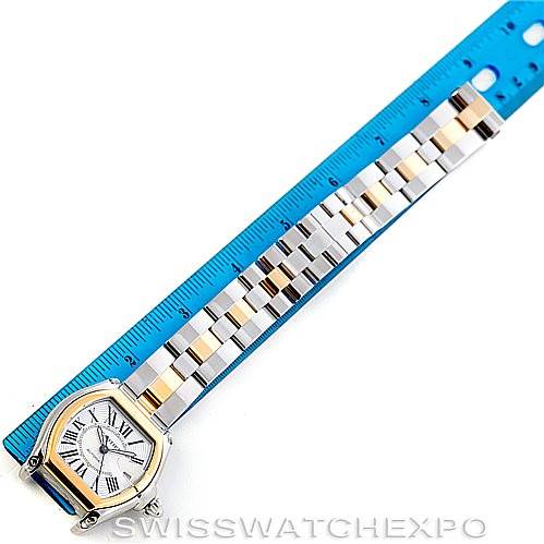 The image shows a Cartier Roadster W62031Y4 Men's Steel and Gold (two tone) Silver Dial W62031Y4 Men's Steel and Gold (two tone) Silver Dial watch face and full bracelet laid flat next to a blue ruler.
