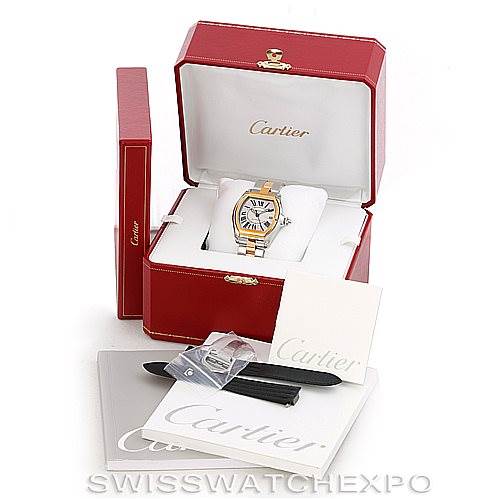 The image shows a Cartier Roadster W62031Y4 Men's Steel and Gold (two tone) Silver Dial W62031Y4 Men's Steel and Gold (two tone) Silver Dial watch in its open box, with extra straps, a booklet, and packaging accessories.