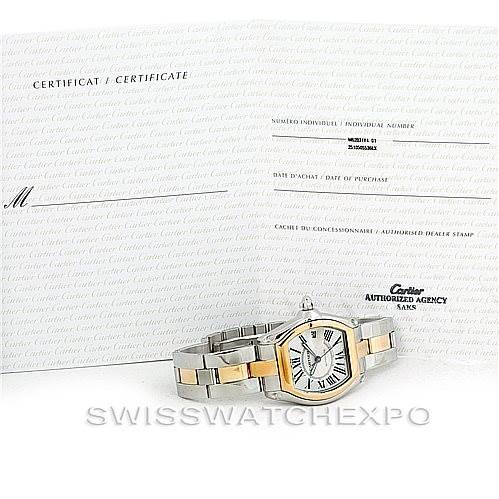 The image shows the Cartier Roadster W62031Y4 Men's Steel and Gold (two tone) Silver Dial W62031Y4 Men's Steel and Gold (two tone) Silver Dial watch at an angle placed in front of its certificate and warranty papers.