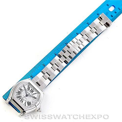 The image shows a top-down view of the Cartier Roadster W62032X6 Men's Stainless Steel Silver Dial W62032X6 Men's Stainless Steel Silver Dial model watch with its face and entire metal bracelet laid out next to a ruler.