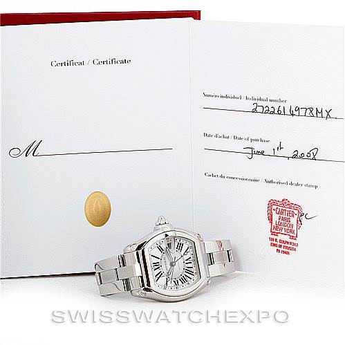 The image shows the Cartier Roadster W62032X6 Men's Stainless Steel Silver Dial W62032X6 Men's Stainless Steel Silver Dial watch along with its certificate of authenticity and warranty documents placed behind it.