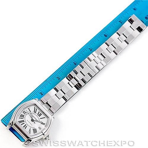 The Cartier Roadster W62025V3 Men's Stainless Steel Silver Dial W62025V3 Men's Stainless Steel Silver Dial watch is shown lying flat with its face and bracelet fully visible, lined next to a blue ruler.