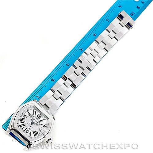 The image shows the top view of a Cartier Roadster W62032X6 Men's Stainless Steel Silver Dial W62032X6 Men's Stainless Steel Silver Dial watch with its strap alongside a measuring ruler.
