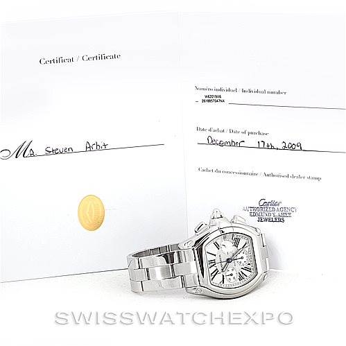 The image shows a Cartier Roadster W62019X6 Men's Stainless Steel Silver Dial W62019X6 Men's Stainless Steel Silver Dial watch at an oblique angle along with its certificate and purchase documentation.