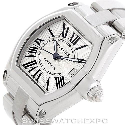 The image shows a Cartier Roadster W62025V3 Men's Stainless Steel Silver Dial W62025V3 Men's Stainless Steel Silver Dial watch from a three-quarter angle, highlighting the face, Roman numeral markers, stainless steel case, and bracelet.