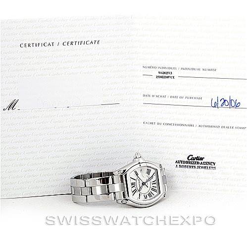 The image shows a Cartier Roadster W62025V3 Men's Stainless Steel Silver Dial W62025V3 Men's Stainless Steel Silver Dial watch lying flat next to certificates and paperwork.