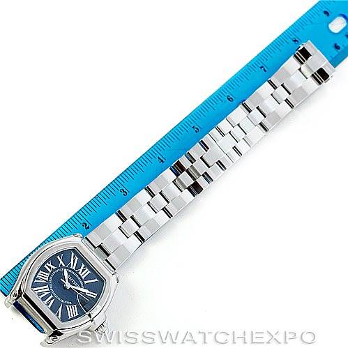 The image shows a top-down view of a Cartier Roadster W6206012 Men's Stainless Steel Blue Dial W6206012 Men's Stainless Steel Blue Dial watch with a blue dial, along with its stainless steel bracelet and a blue ruler for scale.