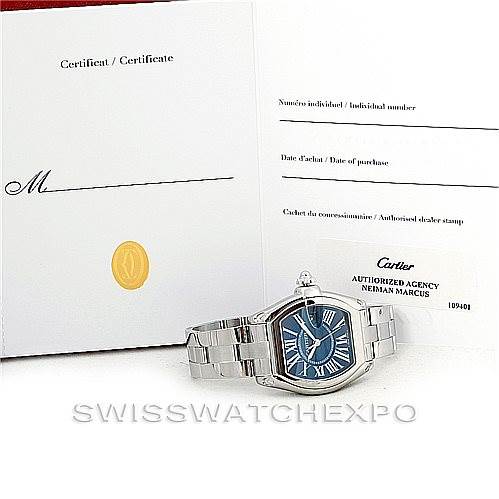 The image shows a Cartier Roadster W6206012 Men's Stainless Steel Blue Dial W6206012 Men's Stainless Steel Blue Dial watch and its certificate placed at an angle, showcasing the watch's front and bracelet.