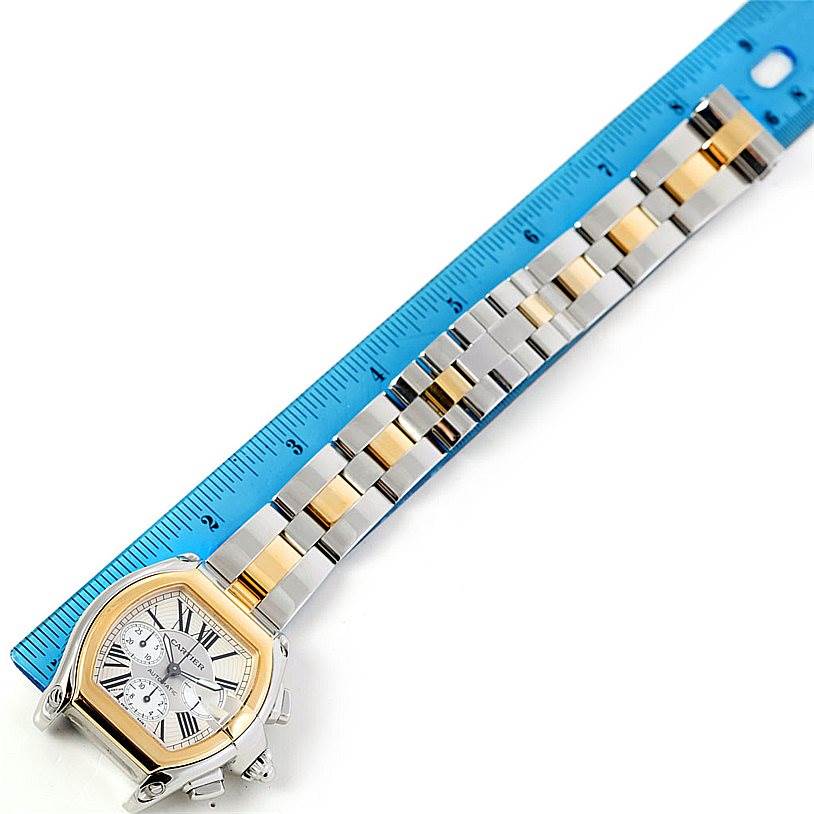 This image shows a Cartier Roadster W62027Z1 Men
s Steel and Gold (two tone) Silver Dial W62027Z1 Men
s Steel and Gold (two tone) Silver Dial watch and its metal bracelet laid next to a ruler at an overhead angle, highlighting its full length.