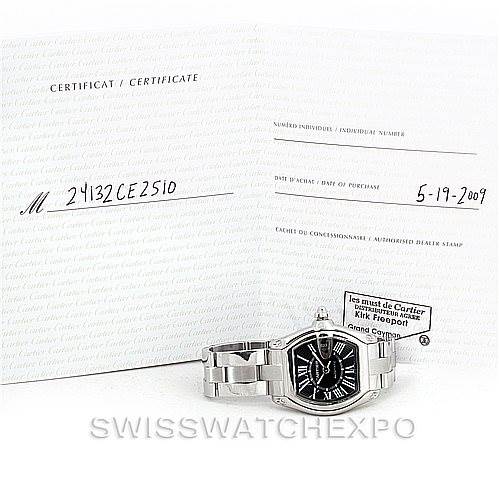 The image shows a Cartier Roadster W62041V3 Men's Stainless Steel Black Dial W62041V3 Men's Stainless Steel Black Dial watch placed in front of its certificate of authenticity and warranty documents.