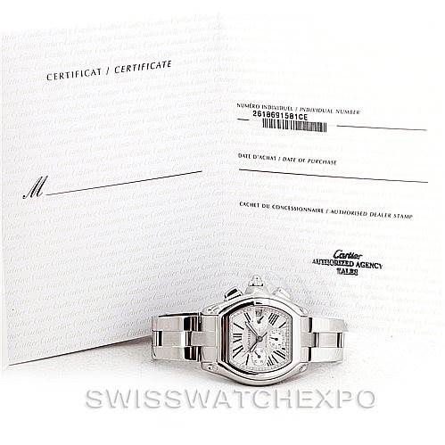 The Cartier Roadster W62019X6 Men's Stainless Steel Silver Dial W62019X6 Men's Stainless Steel Silver Dial watch is shown from the front with its certificate and purchase documents in the background.