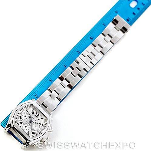 This image shows the Cartier Roadster W62019X6 Men's Stainless Steel Silver Dial W62019X6 Men's Stainless Steel Silver Dial watch laid flat next to a blue ruler, highlighting the watch band and face.