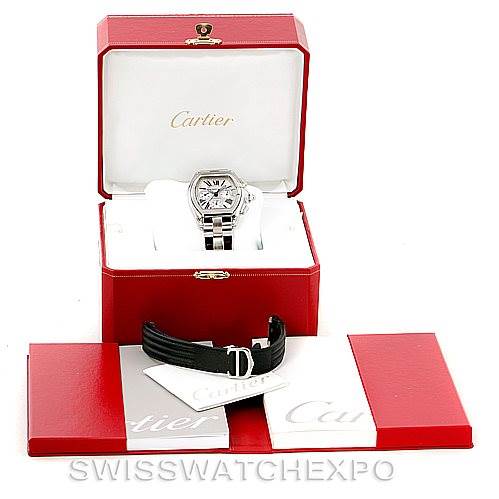 The Cartier Roadster W62019X6 Men's Stainless Steel Silver Dial W62019X6 Men's Stainless Steel Silver Dial watch is shown in its case from an elevated angle, along with a black leather strap and associated accessories.