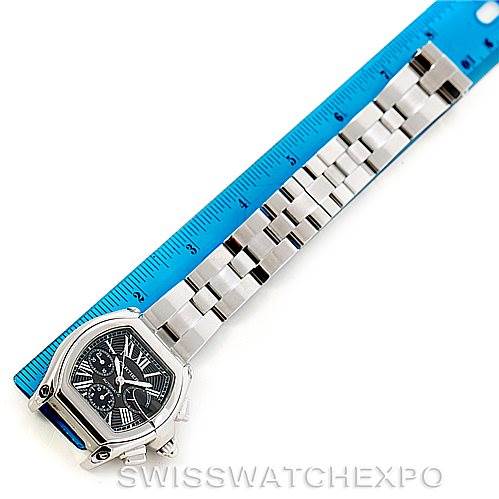 The image shows a Cartier Roadster W62020X6 Men's Stainless Steel Black Dial W62020X6 Men's Stainless Steel Black Dial watch positioned at an angled top view with a blue ruler alongside its stainless steel bracelet.