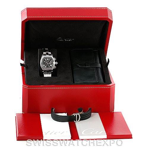 The image shows a Cartier Roadster W62020X6 Men's Stainless Steel Black Dial W62020X6 Men's Stainless Steel Black Dial watch, its black strap, and accompanying accessories in an open red display box.