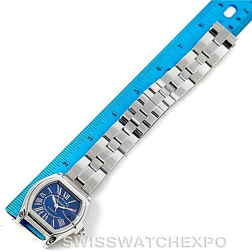 This image shows a Cartier Roadster W62048V3 Men's Stainless Steel Blue Dial W62048V3 Men's Stainless Steel Blue Dial watch laid flat beside a blue ruler, displaying the watch face and bracelet.