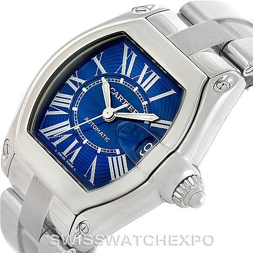 The image shows a Cartier Roadster W62048V3 Men's Stainless Steel Blue Dial W62048V3 Men's Stainless Steel Blue Dial watch from an angled view focusing on the dial, case, crown, and bracelet.