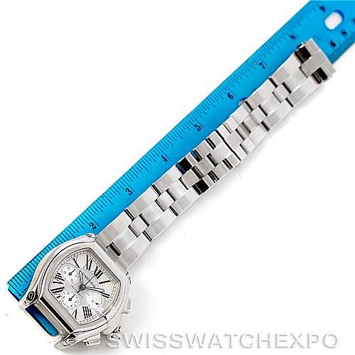 The image shows a top-down view of a Cartier Roadster W62019X6 Men's Stainless Steel Silver Dial W62019X6 Men's Stainless Steel Silver Dial watch, including the face, case, and bracelet, next to a ruler for scale.