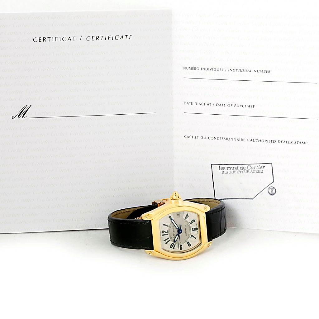 The Cartier Roadster W62005V2 Men's Yellow Gold Silver Dial W62005V2 Men's Yellow Gold Silver Dial watch is displayed front-facing with its certificate behind it.