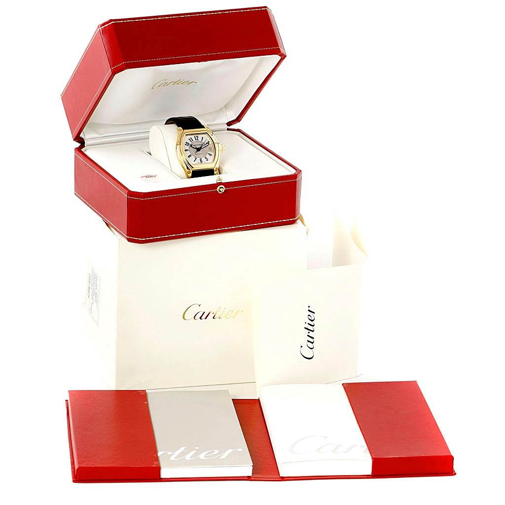 The image shows a Cartier Roadster W62005V2 Men's Yellow Gold Silver Dial W62005V2 Men's Yellow Gold Silver Dial watch in its opened red box, with additional packaging and booklets displayed.