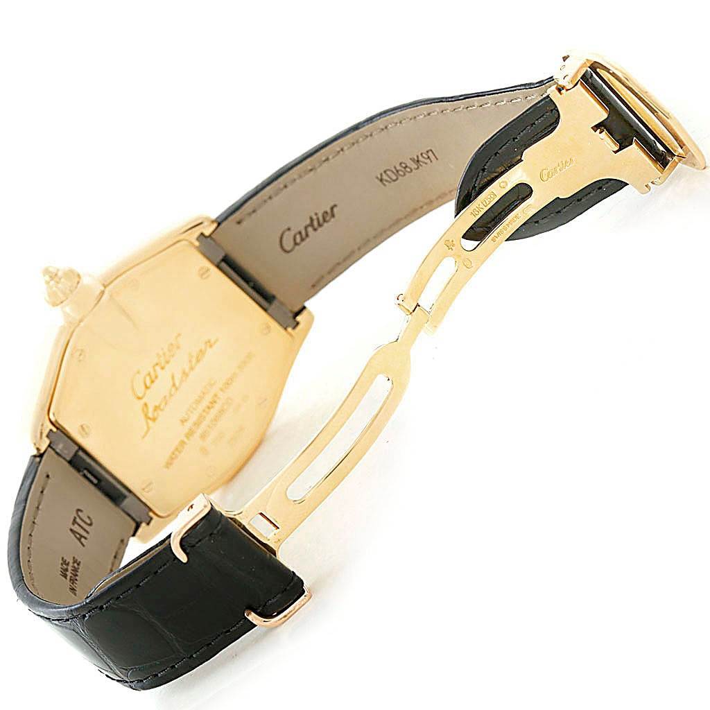 The image shows the backside and clasp of the Cartier Roadster W62005V2 Men's Yellow Gold Silver Dial W62005V2 Men's Yellow Gold Silver Dial watch, highlighting its leather strap and engraved case back.