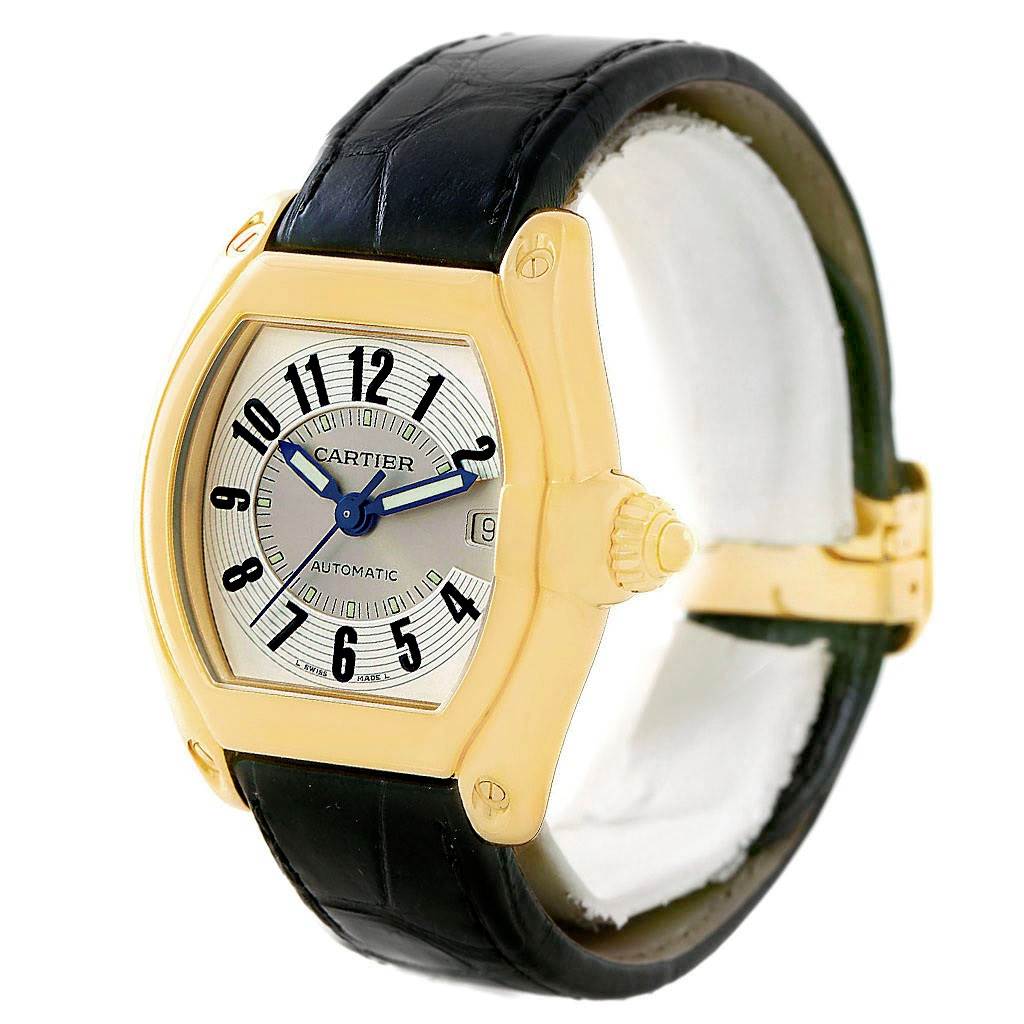 The image shows a Cartier Roadster W62005V2 Men's Yellow Gold Silver Dial W62005V2 Men's Yellow Gold Silver Dial watch at a three-quarter angle, highlighting the dial, crown, and black leather strap.