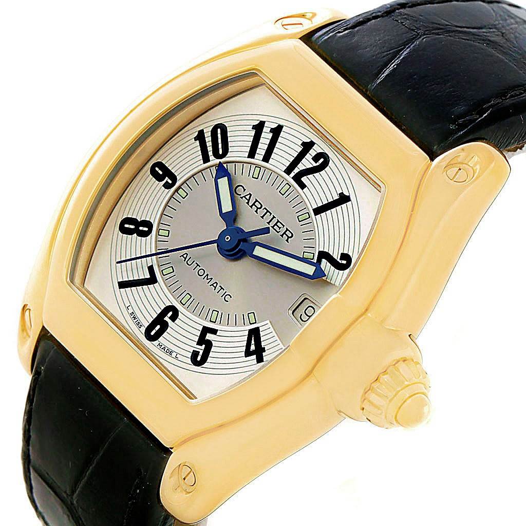 The Cartier Roadster W62005V2 Men's Yellow Gold Silver Dial W62005V2 Men's Yellow Gold Silver Dial watch is shown at a slight angle, highlighting the face, crown, and part of the black leather strap.
