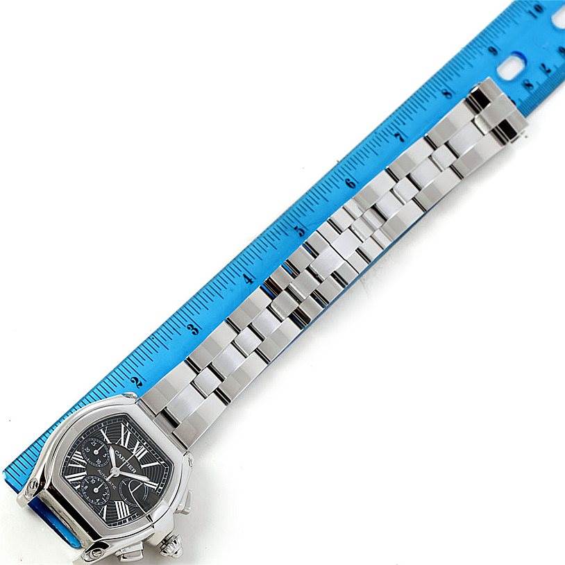 This image shows a top-down view of a Cartier Roadster W62020X6 Men's Stainless Steel Black Dial W62020X6 Men's Stainless Steel Black Dial watch with its metal bracelet positioned next to a ruler for measurement.