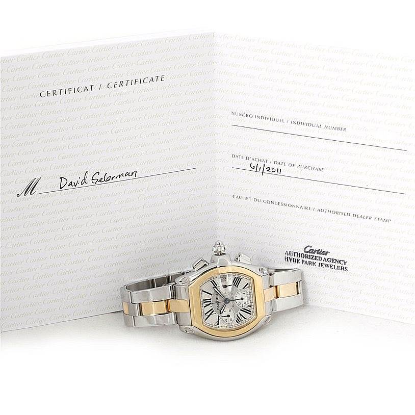 The image shows a Cartier Roadster W62027Z1 Men's Steel and Gold (two tone) Silver Dial W62027Z1 Men's Steel and Gold (two tone) Silver Dial model watch with its certificate of authenticity in the background.