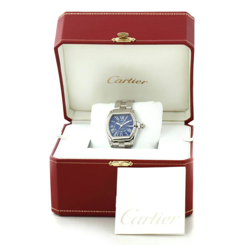 The image shows a Cartier Roadster W62048V3 Men's Stainless Steel Blue Dial W62048V3 Men's Stainless Steel Blue Dial watch in its open, red Cartier box with a pillow cushion and booklet.