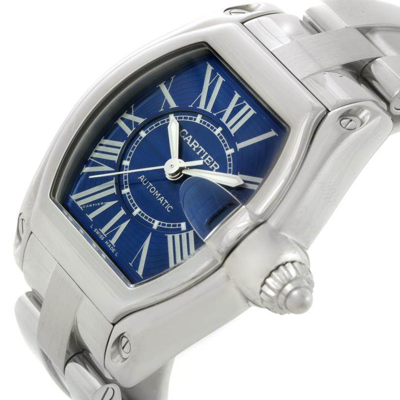 This image shows a close-up, side angle of the Cartier Roadster W62048V3 Men's Stainless Steel Blue Dial W62048V3 Men's Stainless Steel Blue Dial model, highlighting its blue dial, Roman numerals, and silver bracelet strap.