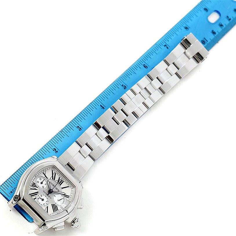 The image shows a top view of the Cartier Roadster W62019X6 Men's Stainless Steel Silver Dial W62019X6 Men's Stainless Steel Silver Dial watch, highlighting its face and metal bracelet with a ruler next to it.